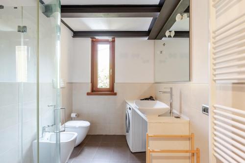 a bathroom with a sink and a toilet and a window at Piacenza Open Space in Piacenza