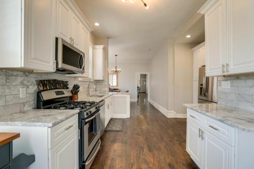 a kitchen with white cabinets and a stove top oven at Spacious Chicago Condo with Deck Less Than 9 Mi to Downtown! in Oak Park