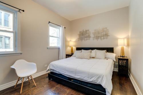 a bedroom with a white bed and a white chair at Spacious Chicago Condo with Deck Less Than 9 Mi to Downtown! in Oak Park