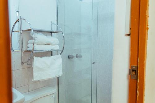 ein Bad mit einer Dusche, einem WC und Handtüchern in der Unterkunft Runcu Arequipa in Arequipa