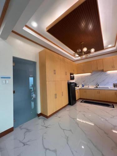 a large kitchen with a refrigerator and a ceiling at Spacious Seaview Studio in Lila, Bohol in Lila