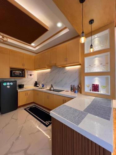 a kitchen with wooden cabinets and a black refrigerator at Spacious Seaview Studio in Lila, Bohol in Lila