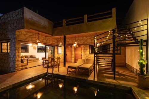 a villa with a swimming pool at night at Smaylo Surf House in Sidi Kouaki