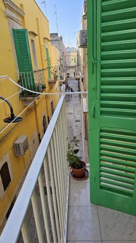 a narrow alley with a green door on a building at Scala Paradiso ~ B&B Molfetta in Molfetta