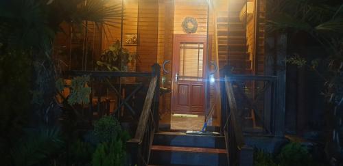 a house with a red door and a stairway at wooden villa in Mardakan