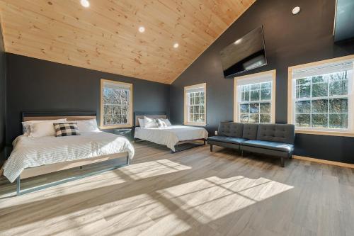 Un dormitorio con dos camas y un televisor de pantalla plana. en Lakefront Home with Private Beach Access & Hot Tub, en Milton
