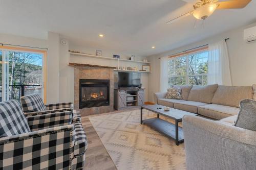 Una sala de estar con un sofá y una chimenea. en Lakefront Home with Private Beach Access & Hot Tub, en Milton