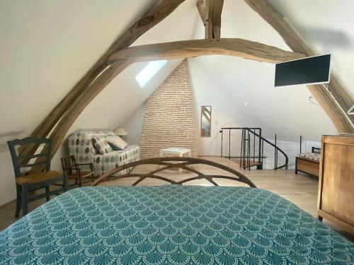 une chambre avec un grand lit dans un grenier dans l'établissement La Petite Maison, à Villetrait
