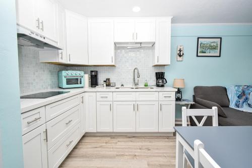a kitchen with white cabinets and a blue wall at Park Place Unit 228 in Cedar Key