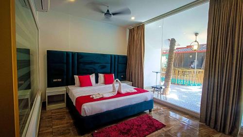 a bedroom with a large bed and a large window at 36 Yard Beach Cottages in Old Goa