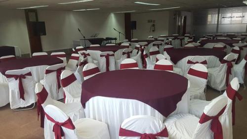 a room filled with tables and chairs with bows at Hotel Narváez Dorado Centro de Convenciones in Tuxtla Gutiérrez