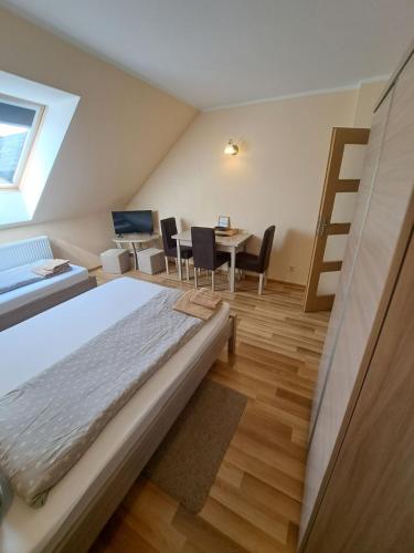 a bedroom with a bed and a table with chairs at SkiBike House Stronie Śląskie in Stronie Śląskie