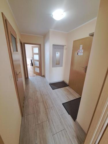 an empty hallway with a door and wooden floors at SkiBike House Stronie Śląskie in Stronie Śląskie