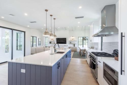 a kitchen with blue cabinets and a white counter top at Brand New Build Larkshine House - Pool in Key West