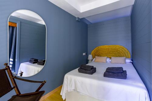 a blue bedroom with a bed with a mirror at TrendyHomes Neptuno Mojacar in Mojácar