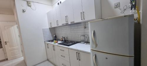 a kitchen with white cabinets and a white refrigerator at Erebuni in Yerevan