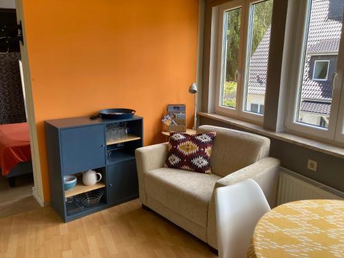 a living room with a chair and a table at Baumwipfel in Hohwacht