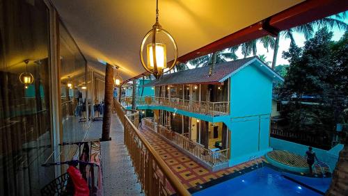 a blue building with a pool and a house at 36 Yard Beach Cottages in Old Goa