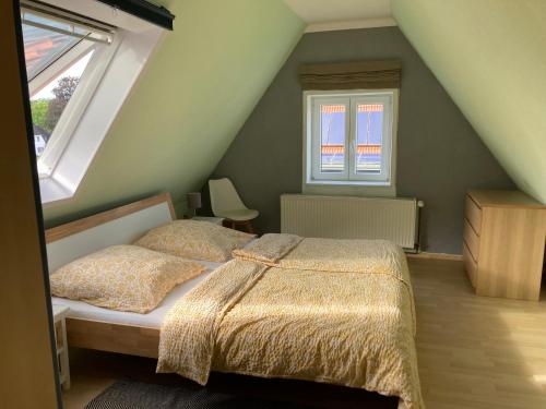 a bedroom with a bed and two windows at Baumwipfel in Hohwacht