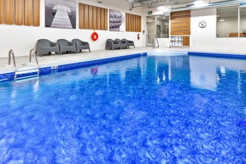 a swimming pool with blue water in a building at Candlewood Suites Trois-Rivières Ouest by IHG in Trois-Rivières