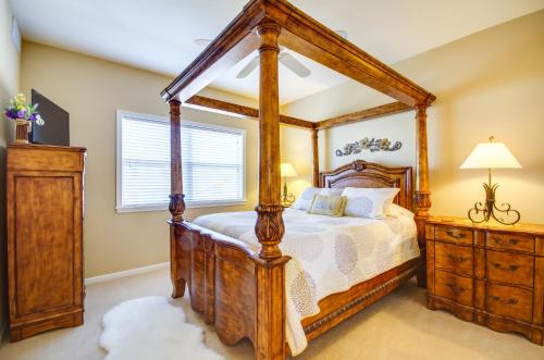 a bedroom with a wooden canopy bed and a window at Pool Access, Water Views Lake Ozark Condo! in Lake Ozark