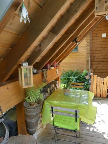 une table avec un tissu de table vert sur une terrasse dans l'établissement Les Trois Lanternes, à Turckheim