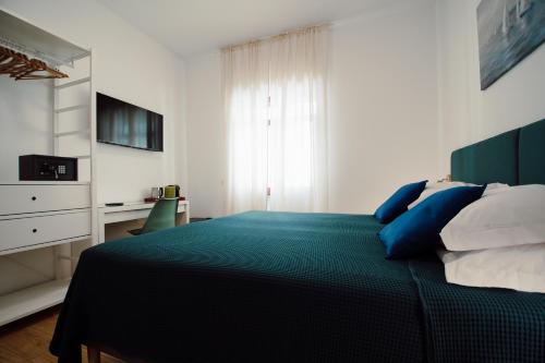 a bedroom with a bed with blue and white pillows at Sweet Dreams in Civitavecchia