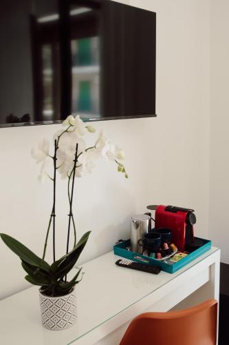 a table with a flower in a vase on it at Sweet Dreams in Civitavecchia