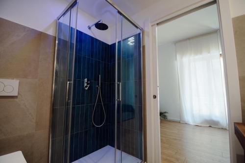 a bathroom with a shower with blue tiles at Sweet Dreams in Civitavecchia