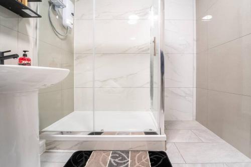 a bathroom with a shower and a sink at LUX 2BDR Flat By Luton Station, Airport, City Centre - 30min to King's X St Pancras International in Luton