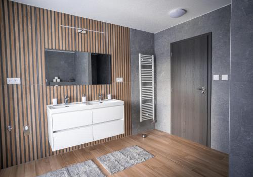 a bathroom with a sink and a television on the wall at Vila Family in Poprad