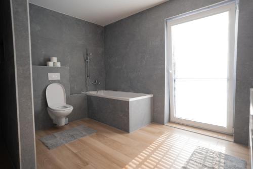a bathroom with a toilet and a sink and a window at Vila Family in Poprad