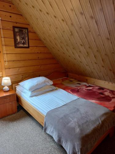 a bedroom with a bed in a wooden room at Bieszczady Domek Letniskowy in Polańczyk