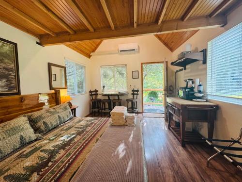 a living room with a couch and a desk at Umpqua's Last Resort - Wilderness Cabins, RV Park & Glamping in Idleyld Park