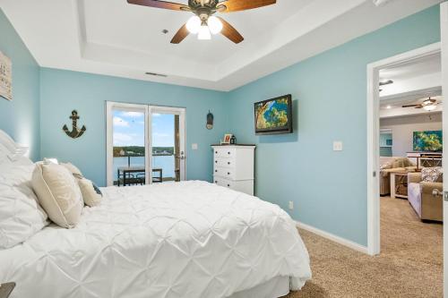 a bedroom with a white bed and a ceiling fan at Emerald Bay Overlook Breathtaking Views, Pools in Lake Ozark