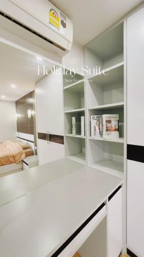 a kitchen with white cabinets and a bed at 2BR Holiday Suite Hat Yai in Hat Yai