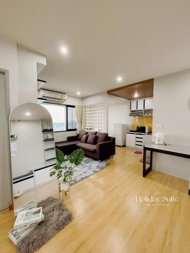 a living room with a couch and a table at 2BR Holiday Suite Hat Yai in Hat Yai