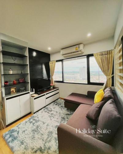 a living room with a couch and a large window at 2BR Holiday Suite Hat Yai in Hat Yai
