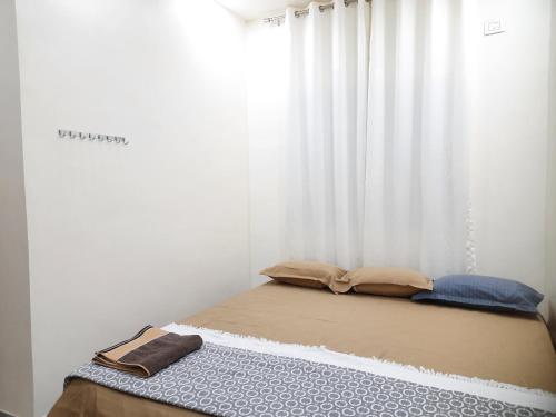 a bed in a room with a window with curtains at Shriguru Guest House Akkalkot in Akalkot