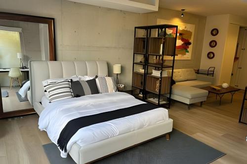 a bedroom with a large white bed and a living room at Inigualable estudio en Condesa in Mexico City