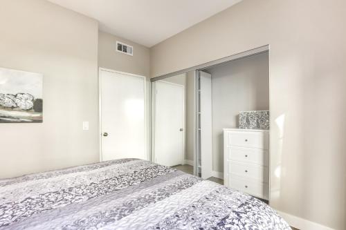 a white bedroom with a bed and a mirror at Sunny San Diego Condo with Pool Access Near Wineries in San Diego
