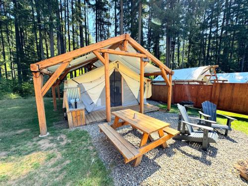 a gazebo with a picnic table and a bench and a tent at Umpqua's Last Resort - Wilderness Cabins, RV Park & Glamping in Idleyld Park