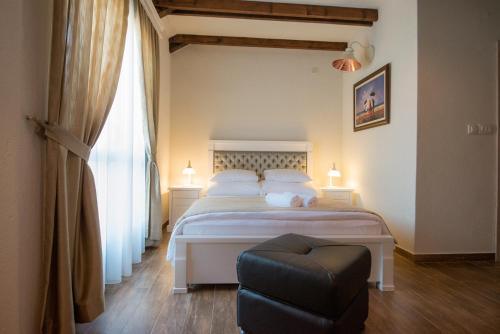 a bedroom with a white bed and a chair at Apartments Marija in Risan