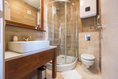 a bathroom with a sink and a shower and a toilet at Apartments Marija in Risan