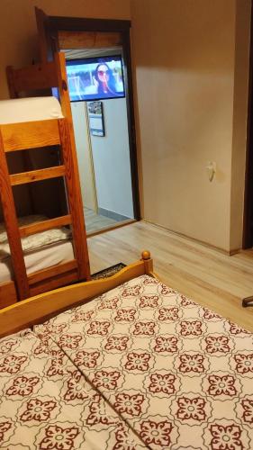 a bedroom with a bed and a door with a screen at agrohaczów zarzeką apartament pod orzechem in Haczów