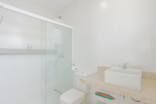 a bathroom with a toilet and a glass shower at GB110 Village Duplex 4 Suítes - Guarajuba in Monte Gordo
