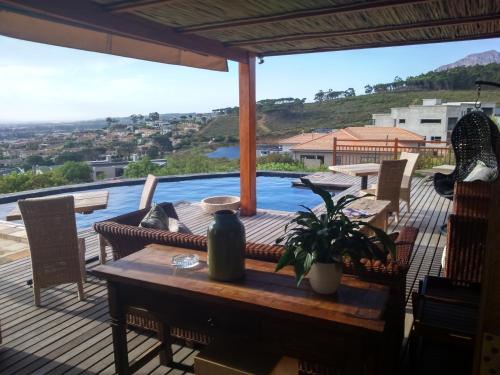 a patio with a table and chairs and a pool at 43 On Sandstone in Somerset West