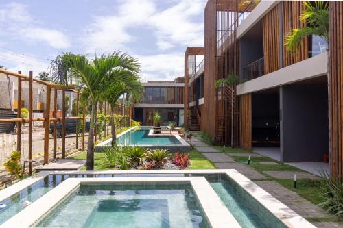 einen externen Blick auf ein Gebäude mit zwei Swimmingpools in der Unterkunft Essence Beira Mar de Tatuamunha na Rota dos Milagres por Quarto à Vista in Tatuamunha