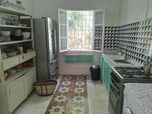 eine Küche mit grünen Schränken und einem Herd in der Unterkunft villa vincente in Salambôo