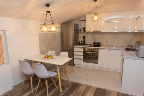 a kitchen with a table and some chairs and a table and a tablektop at Cozy Modern Apartment in Gevgelija